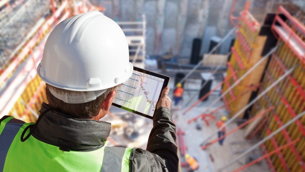A worker looking at a tablet in a construction project - the Industrial Safetytech Regulatory Sandbox,addresses crucial questions regarding the safety implications of emerging
technologies.
